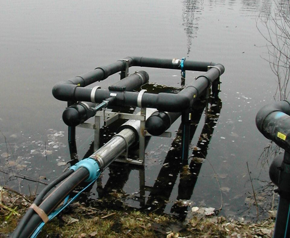 Eine Pumpenplattform, die in einem Teich abgesenkt wird.